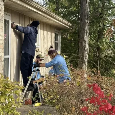 technicians cleaning the exterior of the house